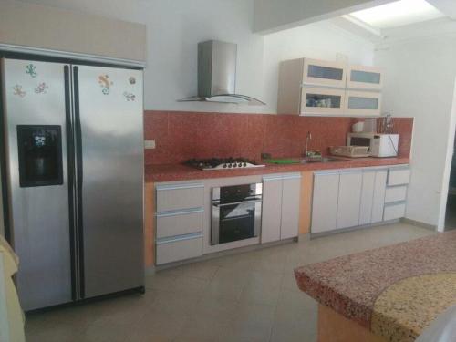 a kitchen with a stainless steel refrigerator and appliances at Casa LA JUANA Condominio El Cortijo in Carmen de Apicalá