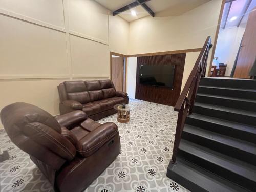 a living room with a couch and a chair and a television at Hotel Lotus in Candolim