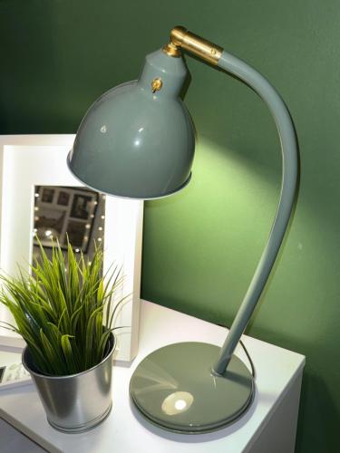 a lamp sitting on top of a desk with a plant at JRE-EG modern aprt01SheikhZayed 5min to ArkanPlaza in Sheikh Zayed