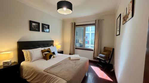 een slaapkamer met een groot bed en een raam bij Madeira Emotions Apartments in Funchal