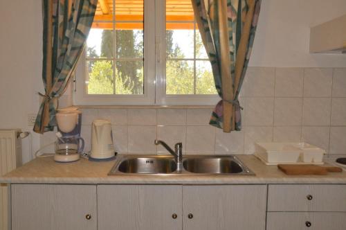 a kitchen counter with a sink and a window at Egli Apartments in Kontokali