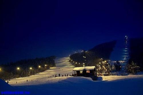 uma pista de esqui coberta de neve à noite com luzes em Volda Turisthotell em Volda