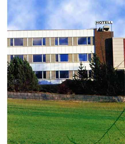 een hotelgebouw met een veld ervoor bij Volda Turisthotell in Volda