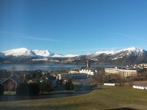 Blick auf eine Stadt mit schneebedeckten Bergen in der Unterkunft Volda Turisthotell in Volda