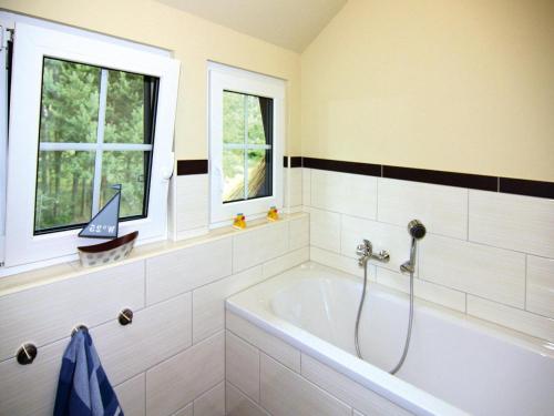 a bath tub in a bathroom with two windows at Ferienhaus Mein Ankerplatz, Zirchow in Zirchow