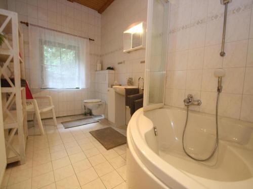a bathroom with a tub and a sink and a toilet at Doppelhaushälfte, Glave in Glave