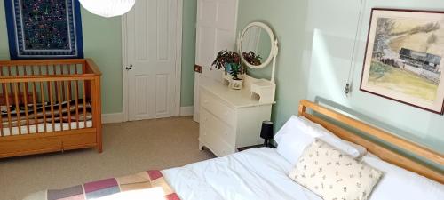 a bedroom with a crib and a mirror at Hill House in Banbury