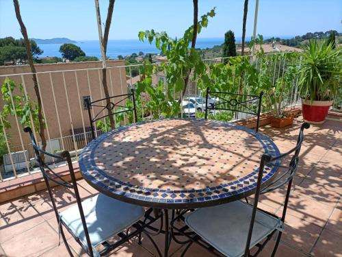 une table et des chaises sur un balcon avec vue sur l'océan dans l'établissement Villa familiale vue mer, à Carqueiranne
