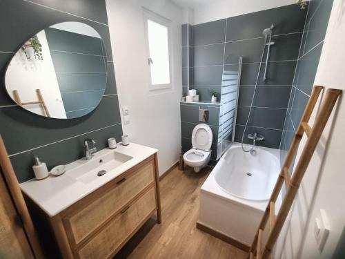 une salle de bain avec un lavabo, des toilettes et un miroir dans l'établissement Villa familiale vue mer, à Carqueiranne