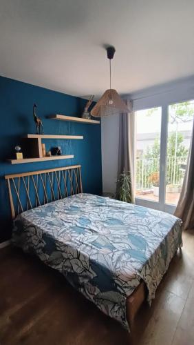 une chambre avec un lit avec un mur bleu dans l'établissement Villa familiale vue mer, à Carqueiranne