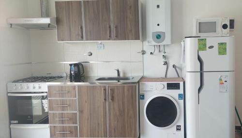 eine Küche mit einem Kühlschrank und einer Waschmaschine in der Unterkunft Sur Bonito in Río Grande