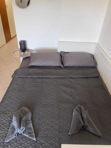 a bed with two pillows and two towels on it at Lovely apartment cosmopoli in Komotini