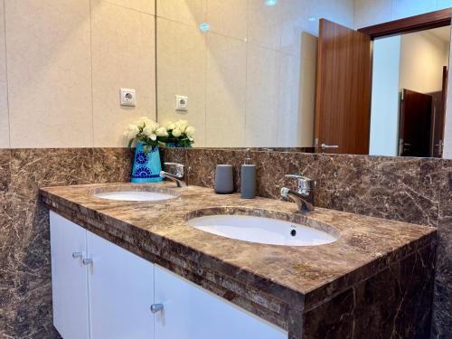 een badkamer met twee wastafels en een grote spiegel bij Madeira Emotions Apartments in Funchal