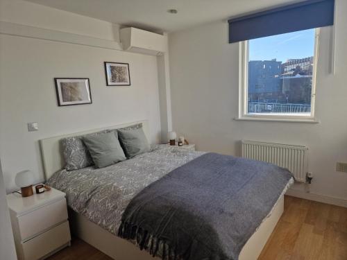 a bedroom with a large bed and a window at Bright and Modern Forest Hill Flat - Flexible Stay in Forest Hill