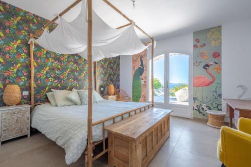 - une chambre avec un lit à baldaquin dans l'établissement Villa Romarine, à Rayol-Canadel-sur-Mer