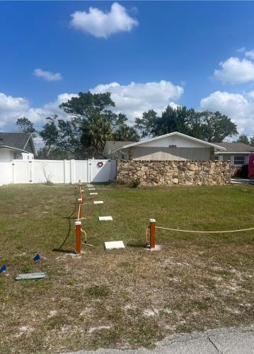 a yard with a fire hydrant and a stone wall at The Suite Picasso in Deltona