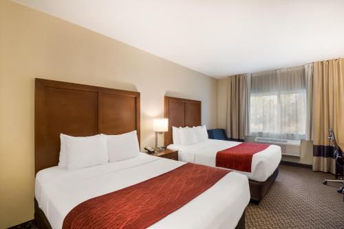 a hotel room with two beds and a window at Comfort Inn Fort Morgan in Fort Morgan