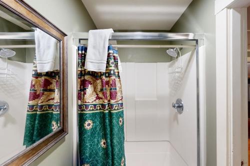 a bathroom with a shower curtain and a mirror at Molalla River Cottage in Molalla