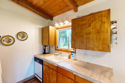 a kitchen with wooden cabinets and a sink at Herb's Hideaway in Twin Rocks