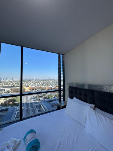 a bedroom with a white bed with a large window at Click Stay - JLT - 2 Bedroom & Balcony Lakes View Entire Apartment -SS in Dubai
