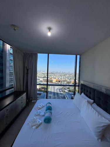 a bedroom with a white bed with a view of a city at Click Stay - JLT - 2 Bedroom & Balcony Lakes View Entire Apartment -SS in Dubai