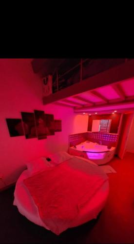 - une chambre dotée d'un lit avec des lumières roses dans l'établissement Appartement port soleil, au Cap d'Agde
