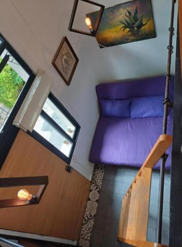 a living room with a purple couch and a staircase at Fernández Leal 55 in Mexico City