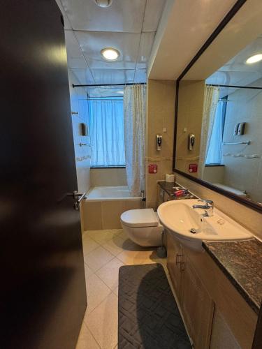a bathroom with a sink and a toilet and a mirror at Click Stay - JLT - 2 Bedroom & Balcony Lakes View Entire Apartment -SS in Dubai