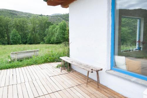 a bench sitting on a porch next to a window at La madriguera azul in Secadura