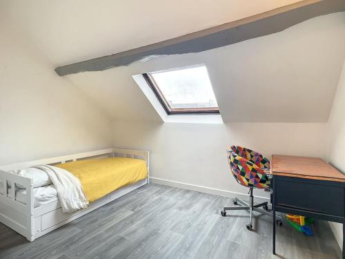 a bedroom with a bed and a desk and a window at Maison 3 chambres in Villemandeur