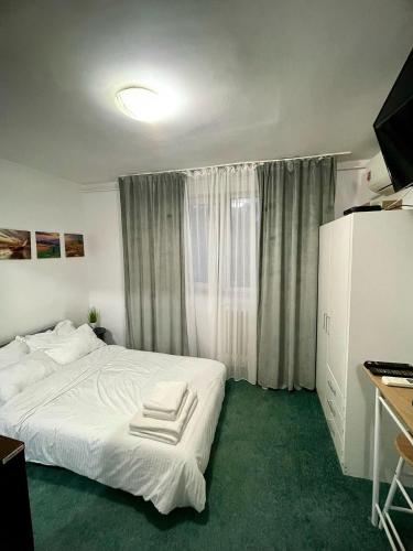 een slaapkamer met een wit bed en een raam bij The Box in Iaşi