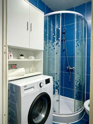 a washing machine in a bathroom with a shower at The Box in Iaşi