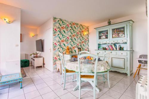 une salle à manger avec une table et des chaises dans l'établissement Duplex face à la mer - Vue Mer & Plage accessible à pieds, à Cabourg