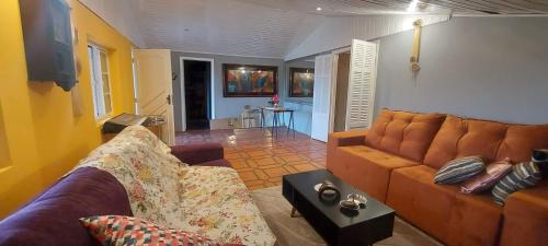 a living room with a couch and a table at Chácara Sitara Lazer e Eventos in Caldas