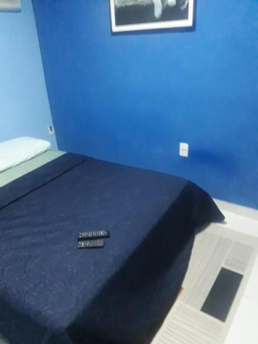 a blue bedroom with a bed with a blue wall at Pousada por do sol in Niterói