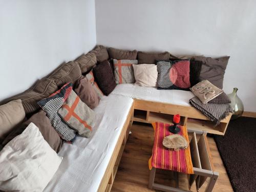 un canapé avec des coussins dessus dans un salon dans l'établissement Le 9 charmant appart meublé de tourisme 2 étoiles centre, à Barcelonnette