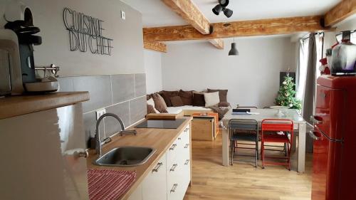 Il comprend une cuisine et un salon avec un réfrigérateur rouge. dans l'établissement Le 9 charmant appart meublé de tourisme 2 étoiles centre, à Barcelonnette