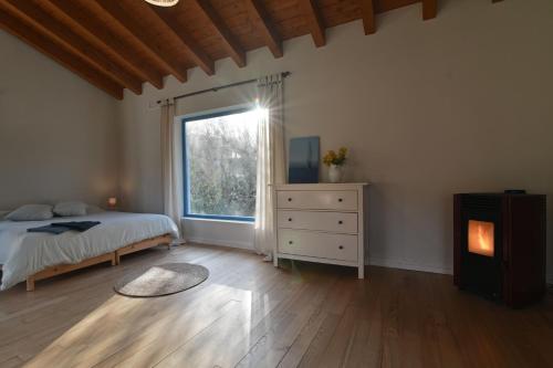 a bedroom with a bed and a window and a dresser at La madriguera azul in Secadura