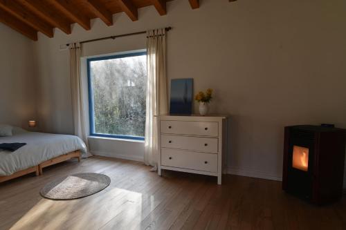 a bedroom with a bed and a window and a dresser at La madriguera azul in Secadura