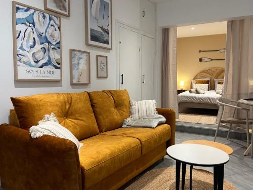 een woonkamer met een bruine bank en een slaapkamer bij NID D'OPALE - Le Portel in Le Portel