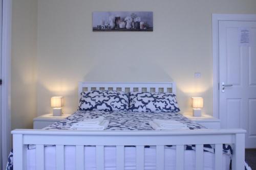 ロンドンデリーにあるBridge Guest Roomsのベッドルーム1室(白いベッド1台、ランプ2つ付)