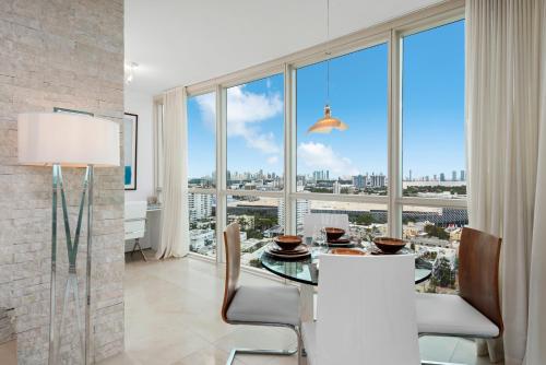 a dining room with a table and chairs and a large window at Oceanview Private Condo at The Setai -2401 in Miami Beach