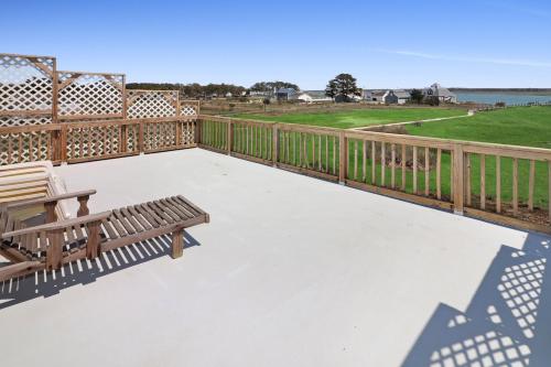 a deck with a bench and a view of the water at Moon Rising - Waterfront with shared dock! in Black Point Landing
