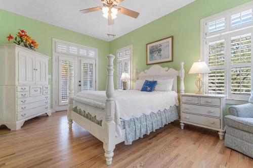 a bedroom with a white bed and green walls at A 4 Bedroom House in Gated Litchfield By the Sea in Pawleys Island
