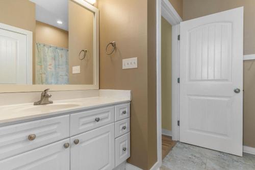 a white bathroom with a sink and a mirror at A 4 Bedroom House in Gated Litchfield By the Sea in Pawleys Island