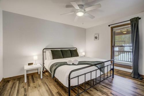 a bedroom with a bed with a ceiling fan and a window at Rustic Outlaw Secluded Escape with Stunning Views in Cripple Creek
