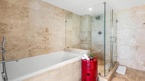 a bathroom with a tub and a glass shower at Oceanview Private Condo at 1 Hotel & Homes -1120 in Miami Beach