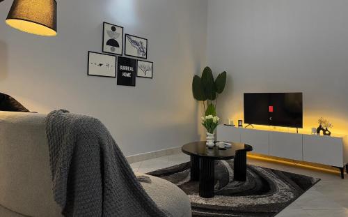 ein Wohnzimmer mit Fernseher, Sofa und Tisch in der Unterkunft Surreal homes in Daressalam