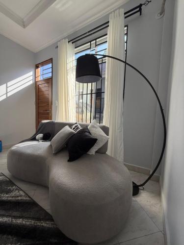 ein Wohnzimmer mit einem großen Bett und einer Lampe in der Unterkunft Surreal homes in Daressalam