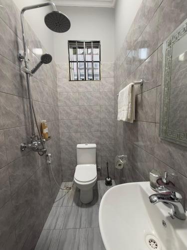 ein Badezimmer mit Toilette und Waschbecken in der Unterkunft Surreal homes in Daressalam